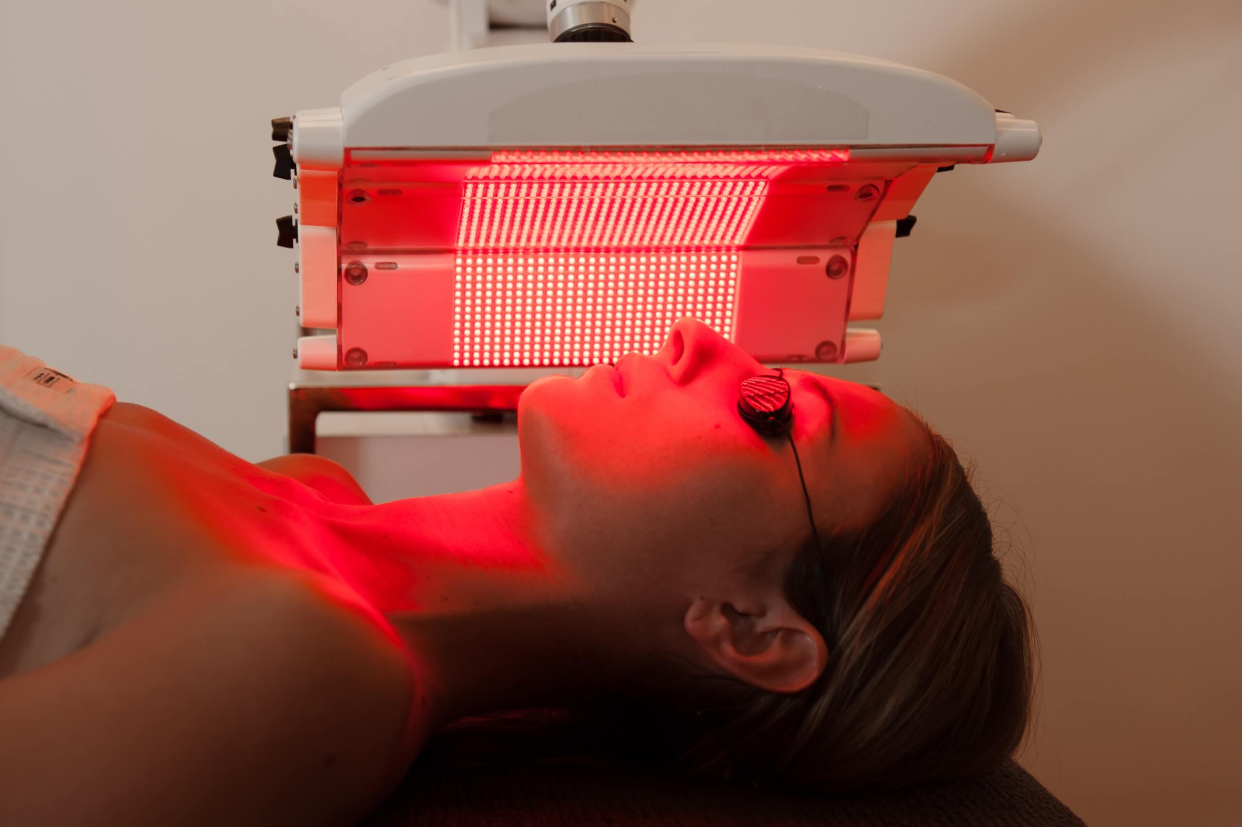 women using red light therapy device at home